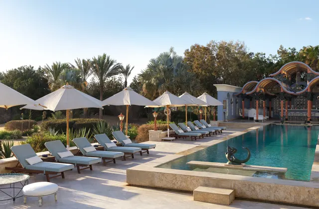 The pool area at La Maison Bleue el Gouna, featuring stylish umbrellas and comfortable lounges for guests to relax and enjoy.