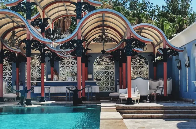 Pool bar at La Maison Bleue El Gouna beneath wave-shaped canopies beside the pool.