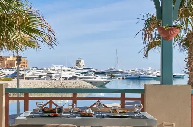 Food being served with a view overlooking the marina filled with yachts.