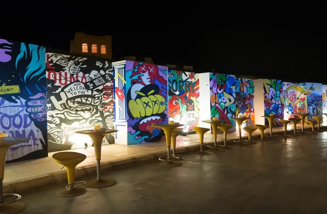 A graffiti wall adorned with colorful artwork, complemented by stylish chairs.