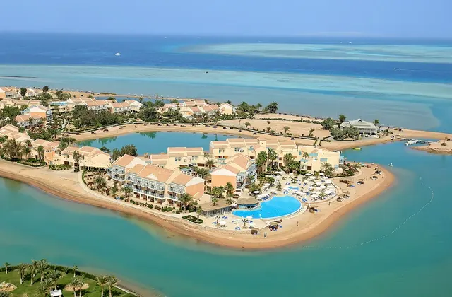 Aerial view of Mövenpick Hotel El Gouna showcasing its pools, a lagoon, and the adjacent Red Sea coastline.