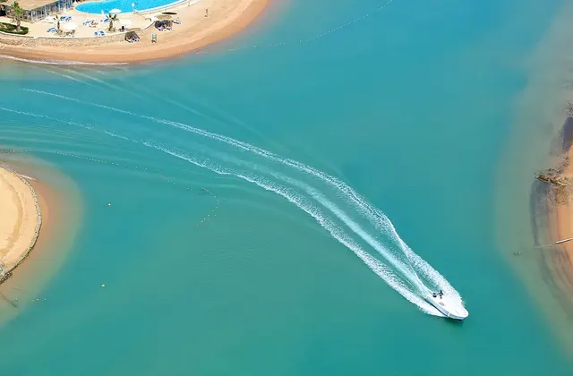 Top view of a lagoon with a boat cruising through the water.