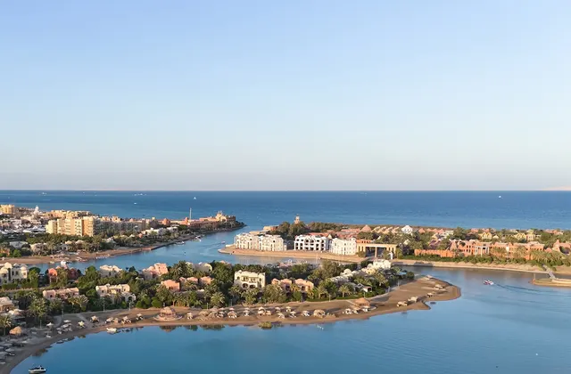 Aerial view of a coastal resort town with lagoons, palm-lined shores and the open sea beyond