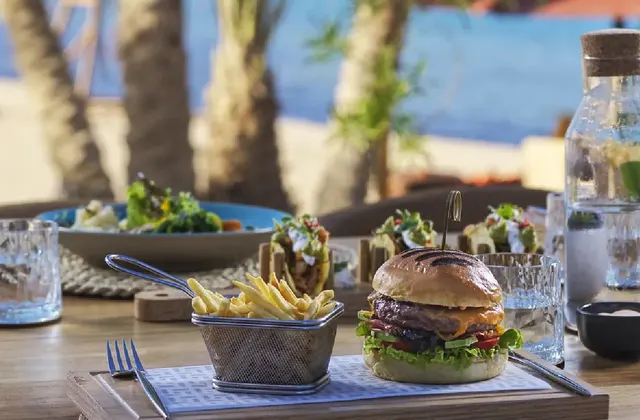 Dining experience at Chedi featuring a gourmet burger with French fries on a stylishly set table.