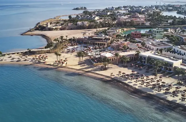 Aerial view of Chedi Hotel with expansive sea view in the background, showcasing its architectural design and coastal setting.