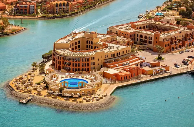 Aerial view of Three Corners Ocean View resort featuring a large pool, sun loungers, and surrounding turquoise waters, highlighting its prime coastal location.